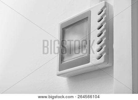 Modern Thermostat On White Wall. Heating System