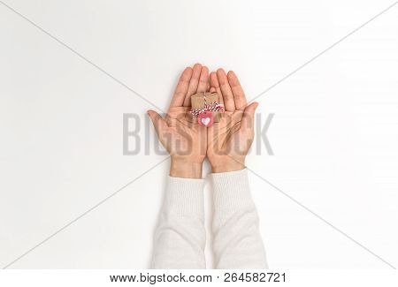 Person Holding A Christmas Gift Box On A White Background