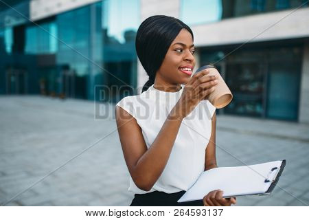 Business girl grinks coffee from cardboard cup