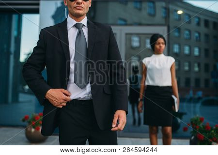 Bodyguard in suit and sunglasses, female VIP