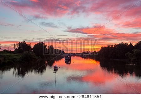 Sunrise Reflections On The Hawkesbury River.  An Old Paddle Wheeler And A Modern Yacht Morred In Its