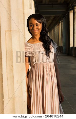 The Young Black Beautiful Woman With Afro Curly Dark Hair Smiling Positively At Camera. Woman Wearin