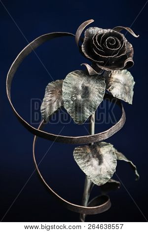 The Broze Rose With A Tape Made Of Metal, On Dark-blue Background.