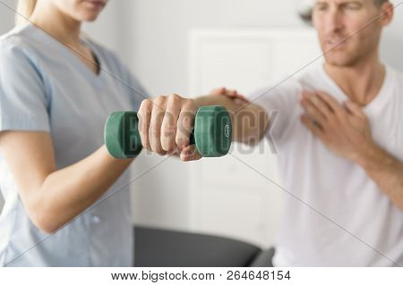 Patient At The Physiotherapy Doing Physical Exercises With His Therapist
