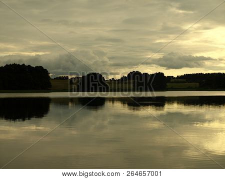 Yellow Sunset Over The Lake And Clouds