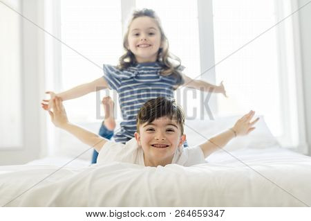 Brother And Sister Having Fun Together On Bed