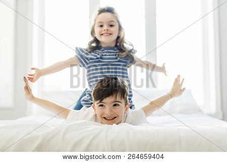 Brother And Sister Having Fun Together On Bed