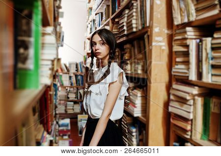Girl With Pigtails In White Blouse At Old Library.
