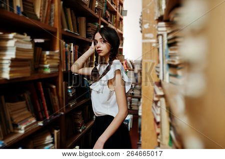 Girl With Pigtails In White Blouse At Old Library.
