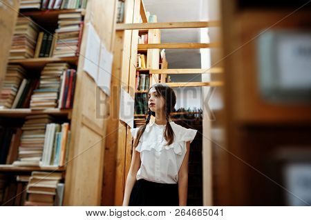 Girl With Pigtails In White Blouse At Old Library.