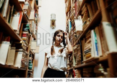 Girl With Pigtails In White Blouse At Old Library.