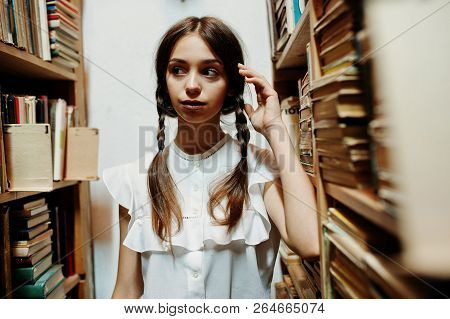 Girl With Pigtails In White Blouse At Old Library.