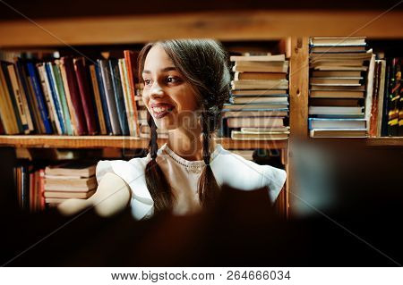 Girl With Pigtails In White Blouse At Old Library.