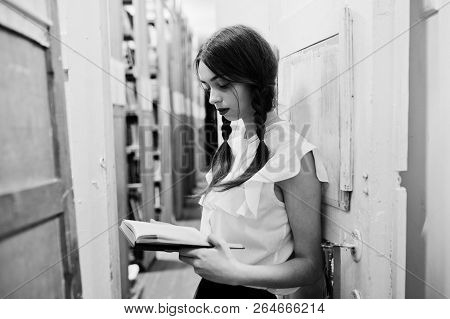 Girl With Pigtails In White Blouse At Old Library.