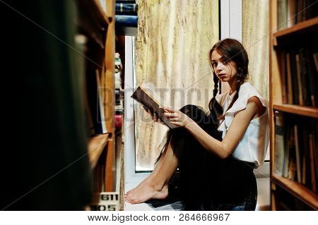 Girl With Pigtails In White Blouse At Old Library.