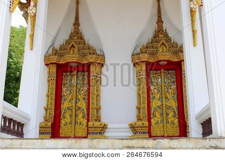 Doors And Windows Of The Temple Adorned By Intricate Wooden Carvings In Golden Color Depicting Buddh