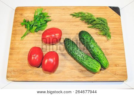 Vegetables Cucumbers Tomatoes On A Wooden Board