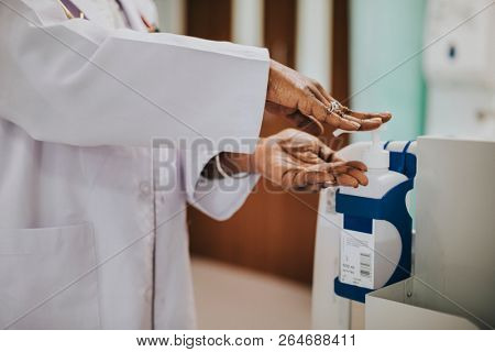Female physician disinfecting her hands