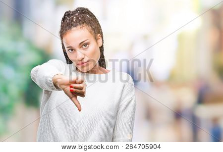 Young braided hair african american girl wearing winter sweater over isolated background looking unhappy and angry showing rejection and negative with thumbs down gesture. Bad expression.