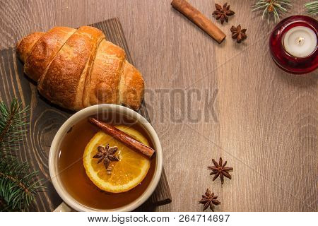 A Cup Of Hot Delicious Tea With A Croissant On A Wooden Platform With A New Years Decor In The Form 