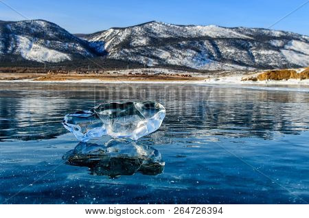 Ice Floe At Frozen Lake Surface With Reflection. Deep Cracks In The Ice And Ice Reflection