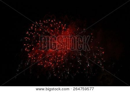 The Celebration Red Colored Firework Flashing In The Black Night Sky