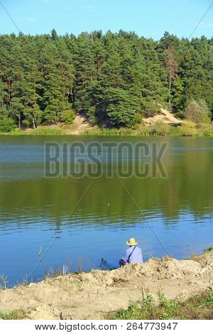 Fisherman Standing On Riverside And Trying To Catch Fish. Male Hobby. Recreation