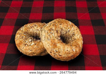 Fresh Multi-grain Bagel Bread, Isolated On A Tartan Red And Black Tablecloth In Background.