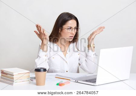 Puzzled Emotive Woman Has Deadline Task, Gesture With Frustration, Stares With Bugged Eyes, Wears Ro