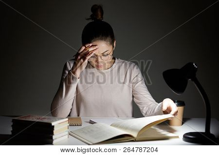 Stressful Schoolgirl Does Home Assigment, Rewrites Information From Book In Notebook, Keeps Hand On 