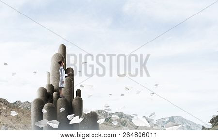 Young Female Doctor With Folder In Hands Satnding On Stone Column