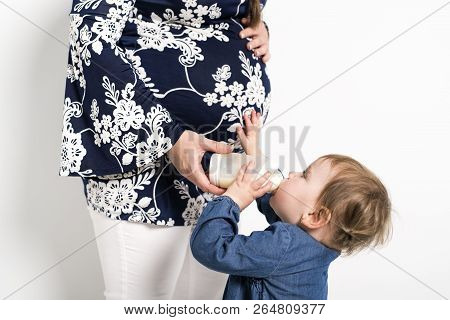 Portrait Of A Pregnant Woman With Baby Child Drink Milk Bottle