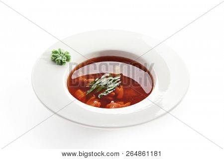 Hot Transparent Soup with Seafood in White Plate Isolated. Sour Spicy Bouillabaisse, Tom Yam, Miso or Halaszle with Red Fish Fillet, Green Onion and Wasabi