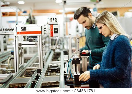 Young Attractive Students Of Mechatronics Working On Project