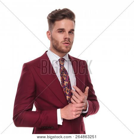 proud businessman in grena suit holding palms together while standing on white background, portrait picture