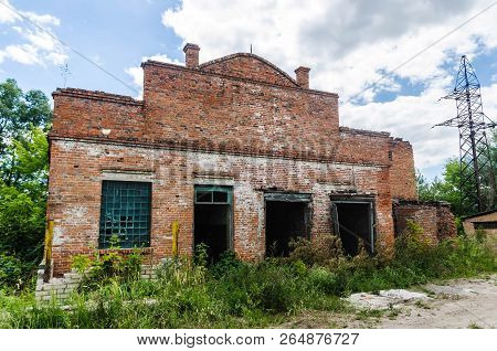 Old Abandoned Ancient Historic Red Brick House On A Background Of Blue Sky And White Clouds. Unusual