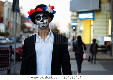 A Man With A Painted Face Of A Skeleton, A Dead Zombie, In The City During The Day. Day Of All Souls