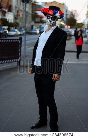 A Man With A Painted Face Of A Skeleton, A Dead Zombie, In The City During The Day. Day Of All Souls