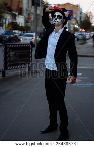 A Man With A Painted Face Of A Skeleton, A Dead Zombie, In The City During The Day. Day Of All Souls