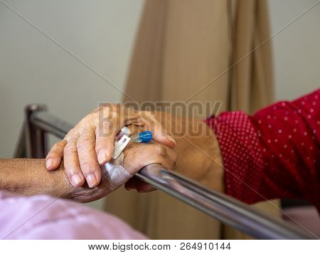 Wife Visiting Husband In Hospital. Senior Couple Holding Hands On Hospital Bed For Hospitalization F