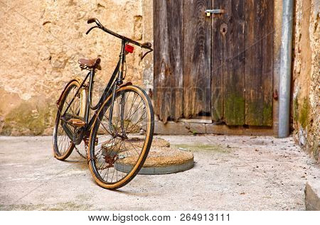 Old retro bicycle on vintage street in Croatia background aged wall and wooden door. City Lovran.
