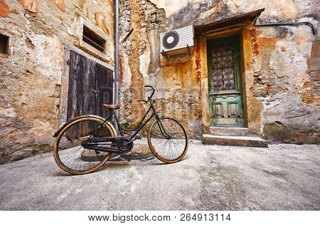 Old retro bicycle on vintage street in Croatia background aged wall and wooden door. City Lovran.