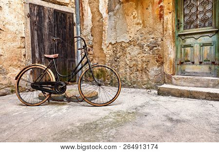 Old retro bicycle on vintage street in Croatia background aged wall and wooden door. City Lovran.