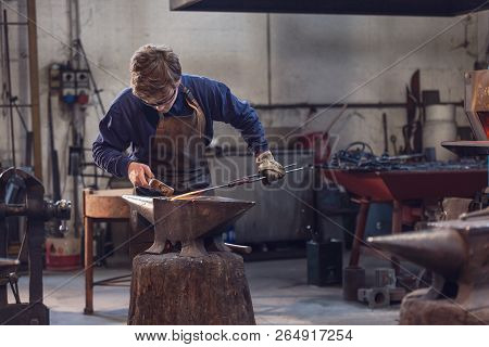 Young Blacksmith Working With Red Hot Metal
