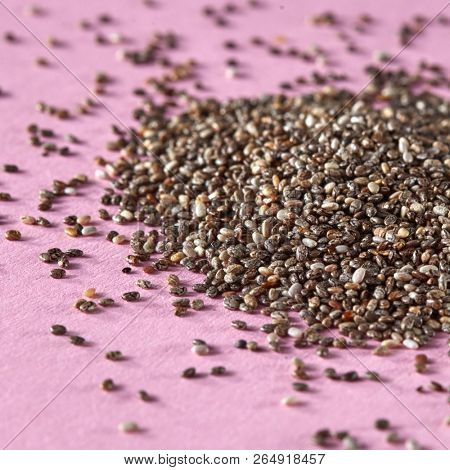 Close up of raw linen seeds in the heap on a pink background. Concept of healthy vegan superfood.