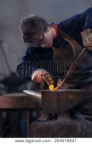 Young Blacksmith Working With Red Hot Metal
