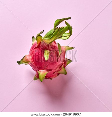 Ripe natural organic exotic fruit- dragon fruit on a pink background, place for text. Top view. Helthy vegan concept.
