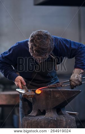 Young Blacksmith Working With Red Hot Metal