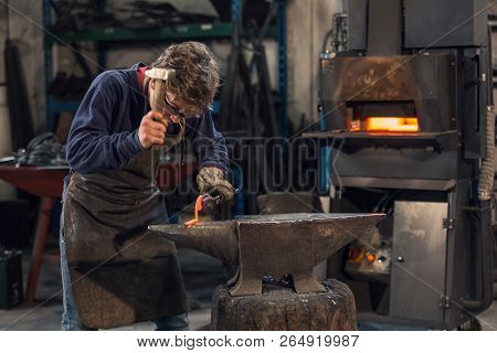 Young Blacksmith Working With Red Hot Metal