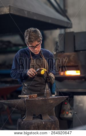 Young Blacksmith Working With Red Hot Metal